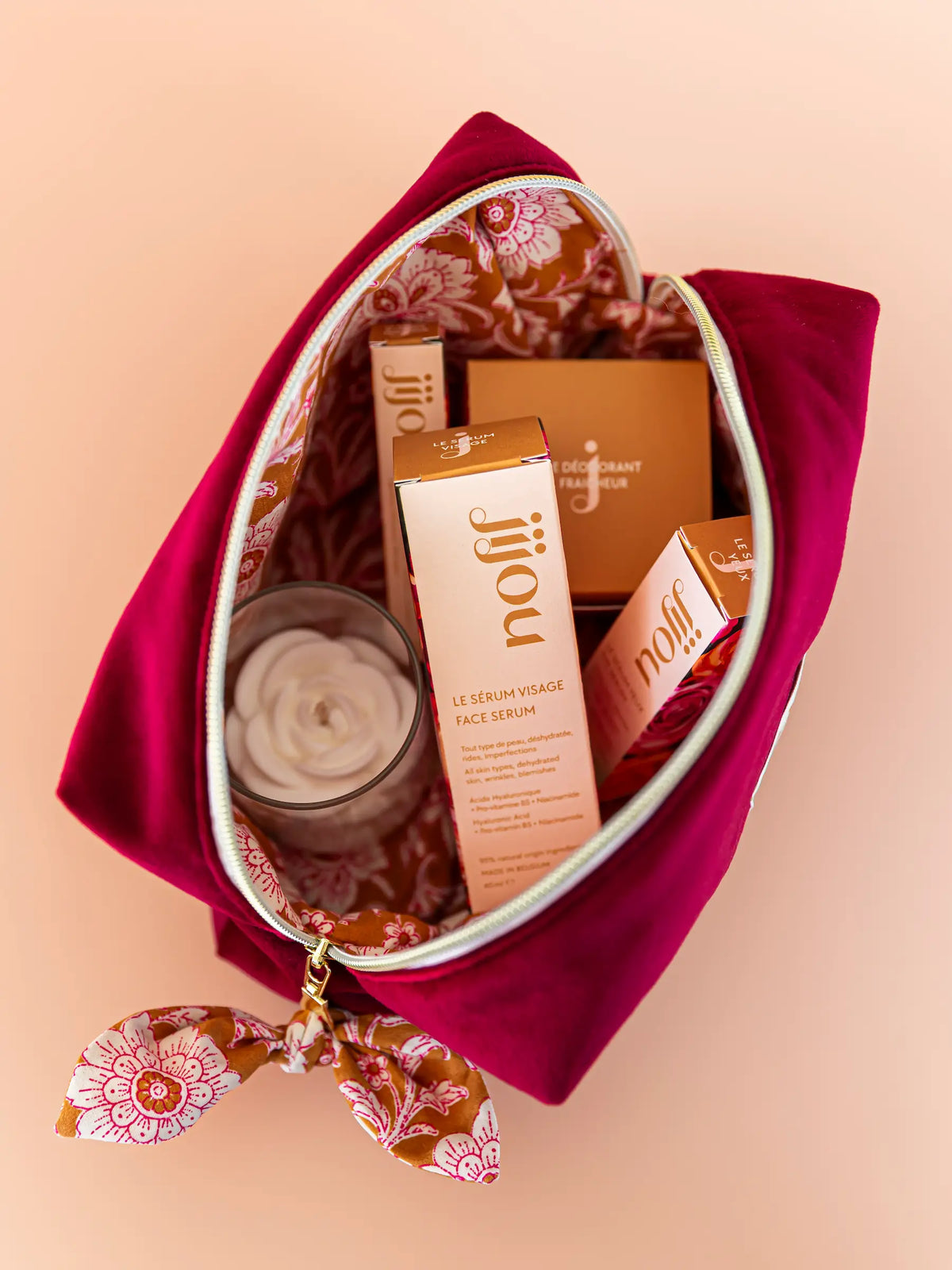 Grande trousse de toilette en velours bordeaux ouverte avec produits de beauté